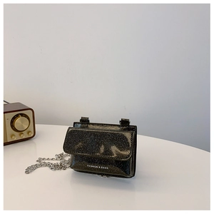 Macro detail of glossy black glitter mini chain bag with FASHION & BAGS text and strap