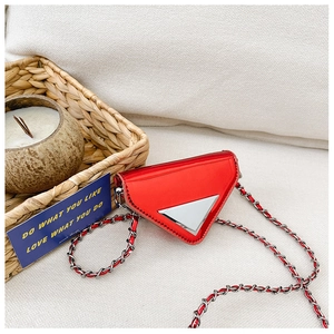 Detail of red patent leather triangle mini bag with silver chain and metal buckle closure
