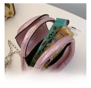 Macro shot of pink sequin crossbody bag interior showing storage space with snacks