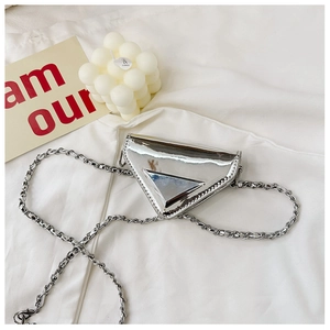 Macro shot of a silver triangular metallic bag with a chain strap and logo detail
