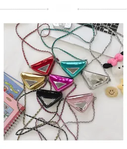 Close-up of seven colorful metallic triangle mini bags with chain straps and metal plates