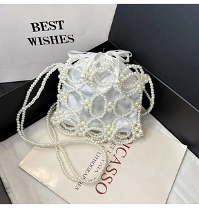 Détail du sac seau en satin blanc avec filet de perles et bandoulière élégante en perles
