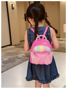 Detail of pink sequin backpack with 3D wings and pearl handle on young girl