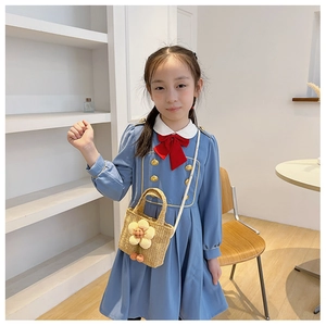 Detailed view of a handmade straw shoulder bag with cute sunflower decoration for kids