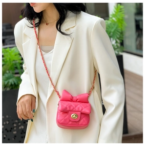 Detail of rose red quilted crossbody bag for kids with bow decoration and gold chain strap
