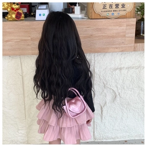 Pink metallic heart-shaped mini crossbody bag for kids shown being worn in use