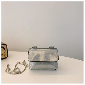 Detail view of mini silver sequin crossbody bag with stylish metal chain and flap closure