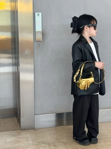 Close-up of golden laser-finish saddle bag for girls with metallic chain handle