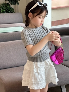 Close-up of a girl's stylish pink metallic saddle bag with trendy fashion outfit details