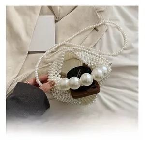 Detail view of woven pearl crossbody bag showing interior capacity for phone and cosmetics