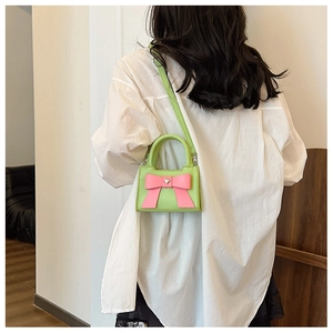 Mini borsa a tracolla verde fluorescente per bambini con fiocco rosa e cuore metallico