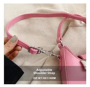 Détail de la bandoulière réglable en similicuir rose avec crochet en métal argenté poli