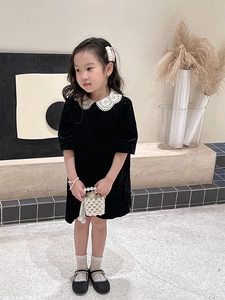 Close-up of black velvet girls dress featuring a white lace Peter Pan collar detail