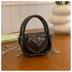 Detail of heart-shaped embossed black sequin mini bag with a silver metal chain strap