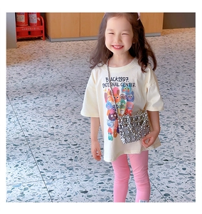 Detail of girls casual cream t-shirt with cartoon print and pink leggings with silver bag