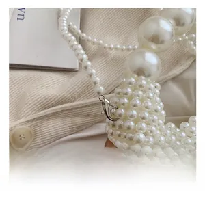 Detail view of handmade white pearl woven strap with a premium silver metal lobster clasp