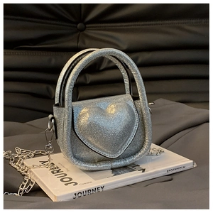 Detail of silver sequin heart crossbody bag with metallic chain and glitter texture