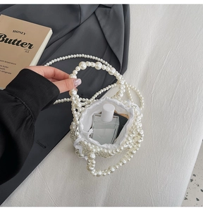Detail of pearl woven bucket bag with white satin drawstring liner and top handle