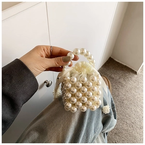 Detail of beaded pearl handbag with cream satin lining and drawstring closure for girls