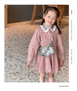 Close-up of a silver metallic beaded crossbody bag paired with a cherry print pink dress