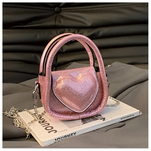 Close-up of pink sequin heart-shaped kids bag featuring a shiny surface and metal chain