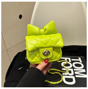 Detail of neon green quilted crossbody bag with a large bow and gold twist lock