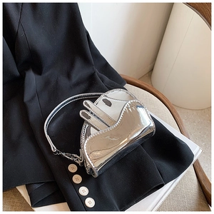 Detail of silver metallic mirror-finish saddle bag for girls with high-shine PU texture