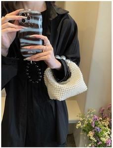 Detail of hand-woven pearl handbag with elegant high-gloss beads and structured grid pattern