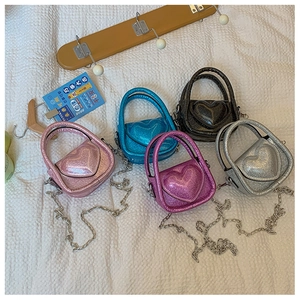 Close-up of glitter heart shaped mini bags with metallic chains in five vibrant colors