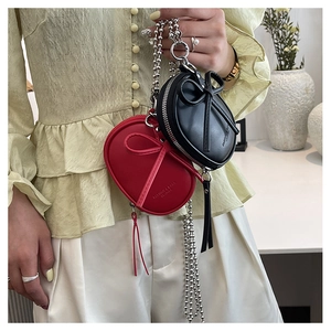 Primer plano de mini bolsos de cuero con lazos 3D y cadenas largas de bolas en rojo y negro
