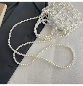 Detail of pearl woven handbag with satin drawstring pouch and detachable pearl strap