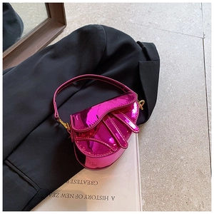 Detailed close-up of girls' metallic pink mini saddle bag with high-gloss laser finish