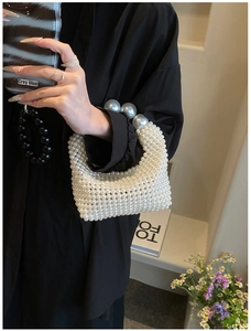 Detailed view of handmade white pearl woven handbag with large decorative pearls
