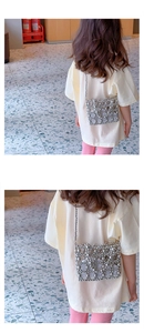 Rear view of a child wearing the silver beaded crossbody bag with elegant bow design