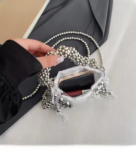 Detailed view of silver metallic beaded handbag with a white satin drawstring liner pouch