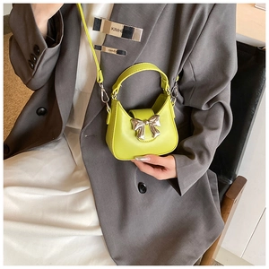 Mini sac à main vert citron à nœud argenté porté avec une tenue de mode moderne