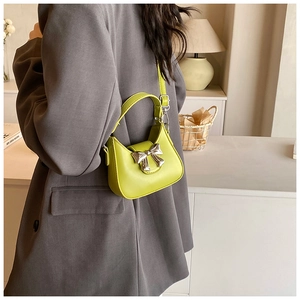 Détail du sac à bandoulière enfant jaune néon avec un élégant nœud en métal argenté
