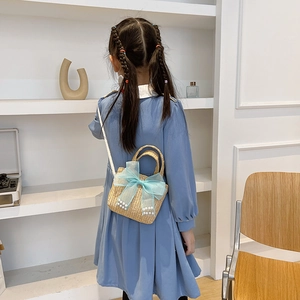 Kids straw crossbody bag featuring light blue mesh bow and elegant pearl accents