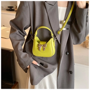 Gros plan du mini sac à main vert fluo avec boucle nœud doré et cuir lisse brillant