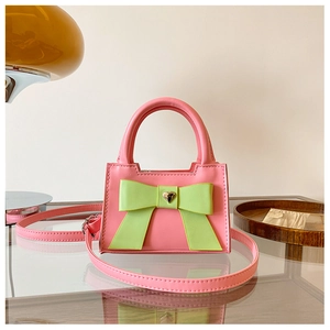 Dettaglio mini borsa a trapezio rosa con fiocco verde neon e fibbia a cuore dorata