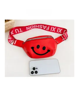 Detailed view of red kids chest bag with smiley face embroidery and fashion strap