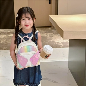 Cute sequined rainbow backpack with pearl handle and wings on a young girl model