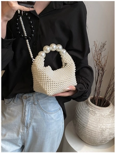 Detail of handmade pearl woven handbag showing the elegant beaded texture and strap