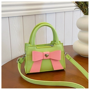 Dettaglio della borsa a tracolla per bambini verde lime con fiocco rosa e cuore