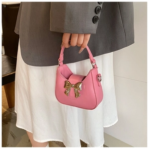 Détail du sac à main rose brillant pour filles avec un nœud métallique doré chic