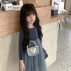 Toddler girl in navy knit top and mesh skirt with a silver heart-shaped sequin crossbody bag