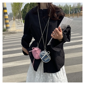 Detalle de mini bolsos bandolera en cuero rosa y denim azul con lazo y cadena de bolas