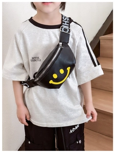 Detail of children's black waist bag featuring a yellow smiley face and fashion strap