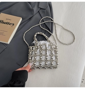 Detail of silver beaded handbag with white satin lining and elegant long chain strap