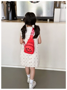 Rear view of a child wearing a red mini chest bag with a smile face pattern